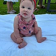 Wesley is registered to the contest to win money with this photo: baby, child, outdoor, grass, blanket, headband, red_clothing, white_clothing, stars_pattern, sitting, person, legs, feet, hand, grass_lawn, summer, garden, people, casual, curious