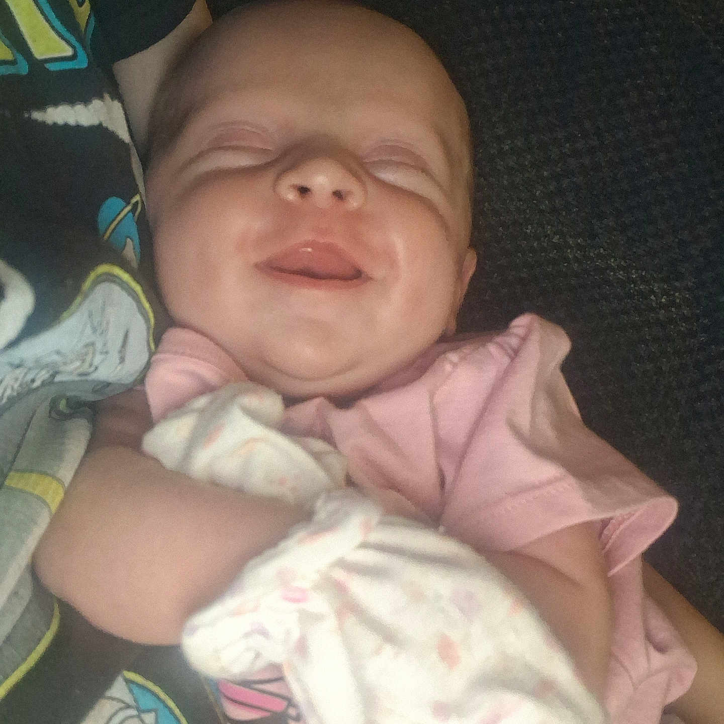 Rosalee is registered to the contest to win money with this photo: arm, baby, blanket, child, closeup, comfort, cozy, cute, face, happy, head, indoor, infant, person, pink_clothing, resting, sleeping, smiling, soft, toddler