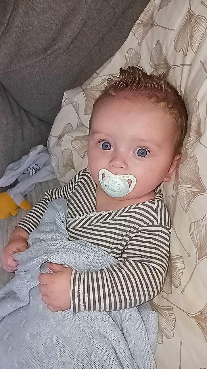 Kélyan participe au concours pour gagner de l'argent avec cette photo : baby, baby_toddler_clothing, cheek, child, chin, comfort, eye, eyelash, facial_expression, hairstyle, iris, linens, lip, nose, pattern, person, product, sitting, skin, sleeve