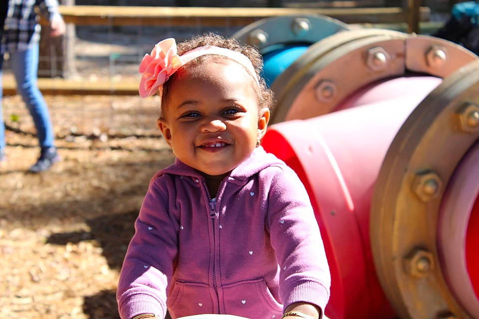 Hannah is registered to the contest to win money with this photo: auto_part, automotive_tire, automotive_wheel_system, child, city, fun, happy, joy, leisure, machine, motor_vehicle, outdoor_play_equipment, people, person, photograph, playground, recreation, smile, snapshot, soil