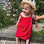 cat_hat, child, curly_hair, fence, greenery, hand, nature, outdoor, person, playful, pond, portrait, red_dress, sandals, smiling, summer, sunlight, support, toddler, wooden_floor