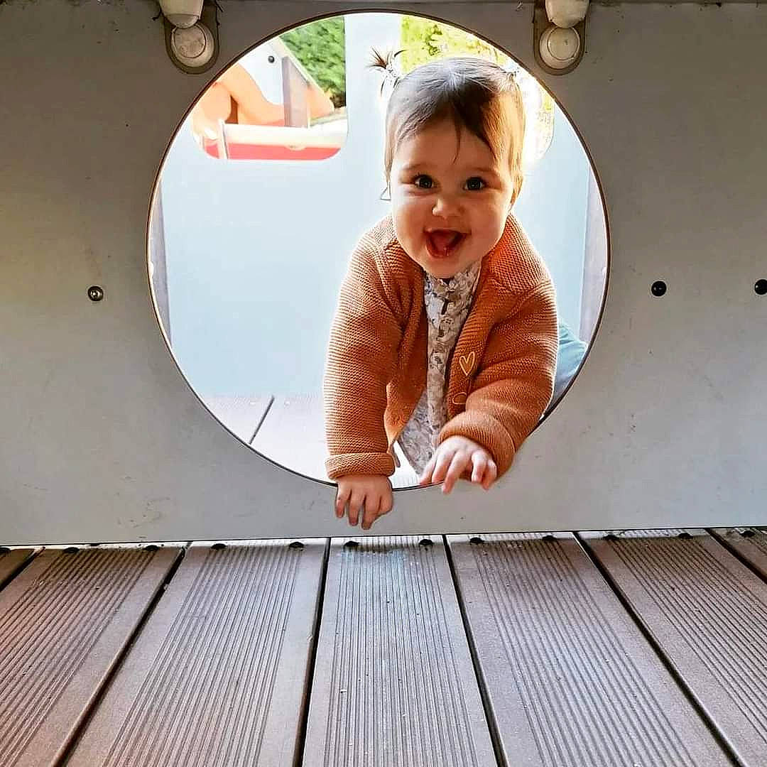 Léna participe au concours pour gagner de l'argent avec cette photo : baby, baby_toddler_clothing, circle, flooring, fun, happy, hardwood, leisure, pattern, person, portrait_photography, room, sitting, sleeve, smile, stairs, t_shirt, toddler, window, wood