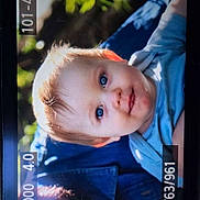 Joseph is registered to the contest to win money with this photo: baby, child, blue_eyes, light_hair, portrait, outdoor, nature, blurred_background, clothing, camera_screen, photography, face, person, young_child, close_up, cute, infant, expression, skin, head
