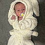 baby, infant, pacifier, white_robe, hood, bunny_ears, fluffy, soft_texture, carpet, lying_down, cute, cozy, newborn, child, small_hands, face, expression, indoor, comfortable, wearing_clothes