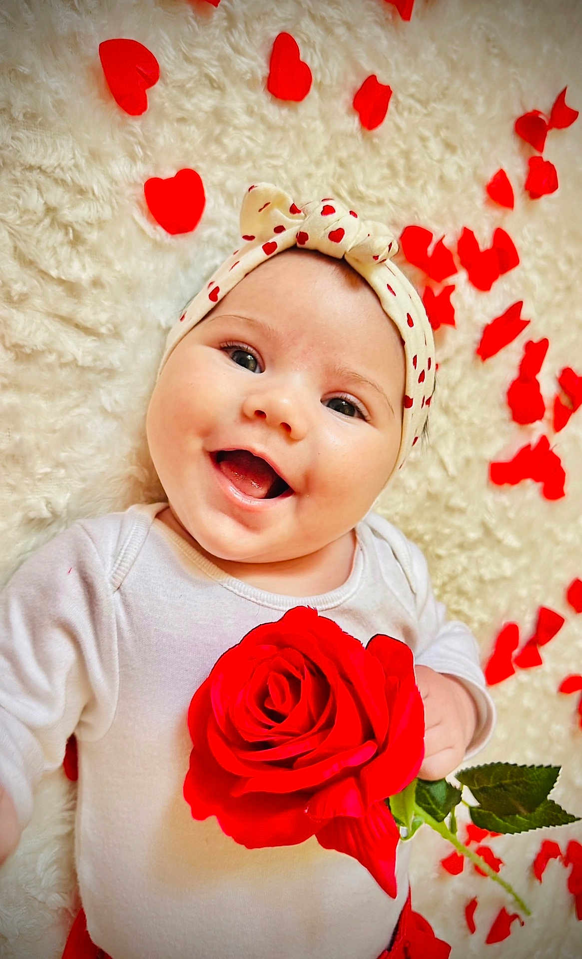 Maëly participe au concours pour gagner de l'argent avec cette photo : baby, infant, smiling, headband, red_rose, rose_petals, white_clothing, fluffy_background, cute, happy, portrait, closeup, lying_down, child, adorable, skin, flower, love_theme, holiday, celebration
