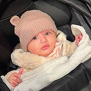 Ayat joined the competition — help win amazing prizes! baby, infant, hat, knit_hat, blanket, stroller, clothing, cute, child, warm, fur_coat, pink, black, face, portrait, outdoor, bundle, small_hands, wide_eyes, curious