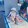 baby, blue, casual, chair, child, cute, daytime, fabric, hat, infant, legs, outdoor, person, poolside, relaxing, shadow, shorts, sitting, summer, sunlight