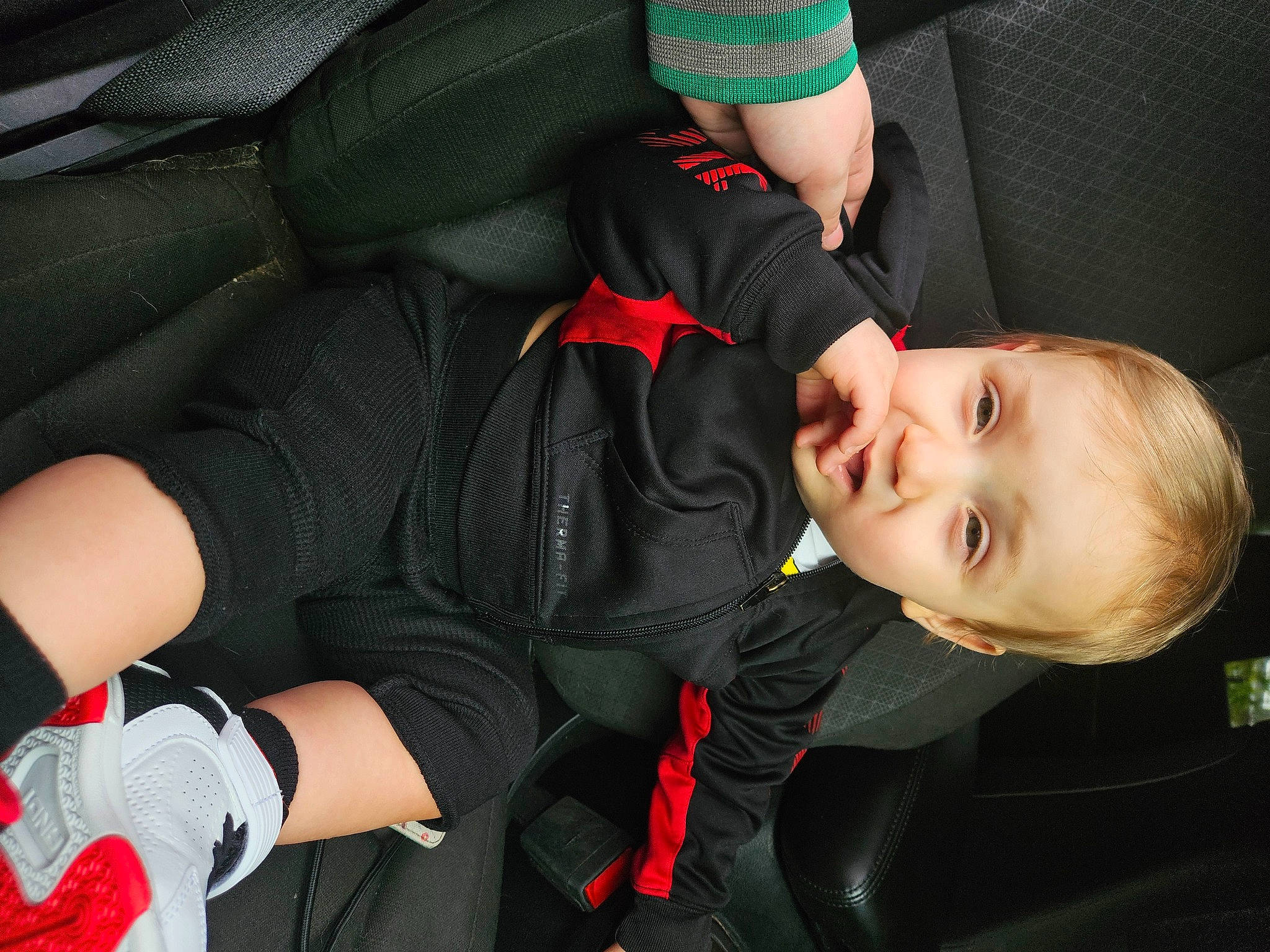 Kylar is registered to the contest to win money with this photo: arm, cap, carmine, child, comfort, flash_photography, fun, grass, happy, human_body, human_leg, joint, knee, lap, outerwear, person, sitting, smile, sports_gear, thigh