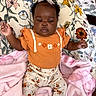 Azalea joined the competition — help win amazing prizes! baby, child, clothing, cozy, cushion, cute, floral_pants, floral_pattern, human, indoor, infant, orange_top, person, pink_blanket, portrait, relaxed, resting, smiling, soft_texture, white_bow