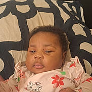 Cassandre participe au concours pour gagner de l'argent avec cette photo : baby, child, infant, onesie, floral_pattern, watermelon_pattern, blanket, face, hand, cute, sleepy, lying_down, black_and_white, pattern, indoors, person, soft_lighting, closeup, expression, cozy