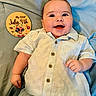baby, smiling, shirt, pants, blanket, sign, celebration, holiday, july_4th, infant, cute, portrait, lying_down, happy, child, face, buttoned_shirt, blue, hand, skin