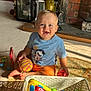 toddler, child, smiling, indoor, carpet, toy, basket, colorful, fireplace, brick, shirt, orange_shorts, happy, person, foot, playtime, home, light, shadow, living_room