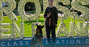 Mylo a rejoint le concours — aidez-le/la à gagner de superbes lots ! blue_sky, building, casual_clothing, daylight, decor, dog, glasses, grass, happy, leisure, nature, outdoor, park, person, shadow, signage, sitting, standing, sunlight, trees