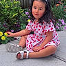 cherry_pattern, child, colorful, dress, flowers, garden, girl, nature, outdoor, patio, plants, portrait, portrait_photography, sandals, sitting, smiling, toddler, white_bow, wooden_fence, yellow_flower