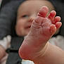 baby, foot, toes, infant, car_seat, smile, child, skin, closeup, blurred_background, seatbelt, human, cute, soft_light, indoor, childhood, baby_clothes, playful, small, person