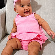 Nasya Ellie is registered to the contest to win money with this photo: baby, child, infant, smiling, happy, portrait, pink_outfit, pink_bow, headband, sitting, armchair, indoor, couch, fashion, sparkly_shoes, dress, romper, bare_legs, joyful, photography