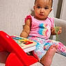Nasya Ellie is registered to the contest to win money with this photo: baby, child, toddler, sitting, chair, portrait, smiling, hair_bows, pink_shirt, pineapple_design, colorful_clothing, patterned_pants, barefoot, toy, red_toy, musical_toy, cup, indoors, furniture, playtime