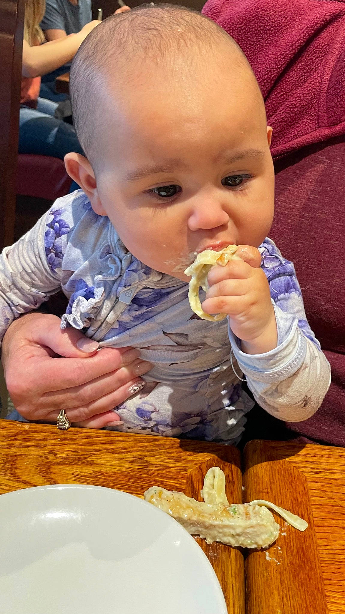Nola is registered to the contest to win money with this photo: baby, baby_toddler_clothing, biting, chair, cuisine, dish, dishware, finger, food, food_craving, hand, orange, people, person, plate, sharing, table, tableware, toddler, wood