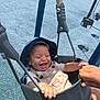 Jasper is registered to the contest to win money with this photo: baby, child, swing, playground, hat, overalls, smile, laughing, hand, outdoor, fun, joy, happy, seat, blue, fabric, metal, person, daylight, recreation