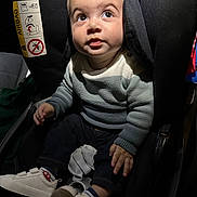 Gabriel a rejoint le concours — aidez-le/la à gagner de superbes lots ! toddler, child, car_seat, sweater, white_shoes, plush_toy, curious, indoor, seat_belt, baby, footwear, clothing, portrait, small_hands, looking_up, cute, casual_wear, child_safety, infant, soft_lighting