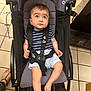 Gabriel participe au concours pour gagner de l'argent avec cette photo : baby, child, stroller, infant, striped_shirt, shorts, black_straps, patterned_cushion, tiled_floor, footwear, barefoot, curious_expression, indoor, person, seated, looking_up, baby_clothing, young_child, cute, casual