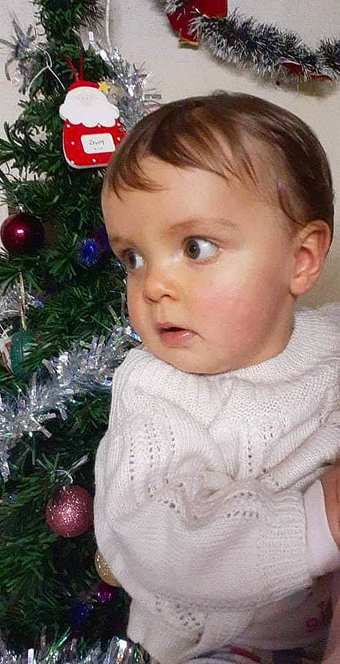 Lorie-rose participe au concours pour gagner de l'argent avec cette photo : baby_toddler_clothing, cheek, christmas_decoration, christmas_ornament, christmas_tree, eye, eyelash, facial_expression, happy, holiday_ornament, iris, lip, nose, organ, ornament, person, skin, sleeve, standing, toddler