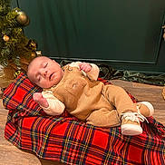 Alaz a rejoint le concours — aidez-le/la à gagner de superbes lots ! baby, sleeping, blanket, tartan, christmas_tree, ornaments, wooden_floor, overalls, shoes, infant, holiday, festive, cozy, indoor, decor, relaxing, cute, child, person, portrait