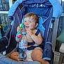 baby, child, stroller, blue, rattle, water_bottle, evian, smile, happy, indoor, seat_belt, diaper, toy, person, furniture, window, curtain, floor, chair, portrait