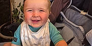 Sergio participe au concours pour gagner de l'argent avec cette photo : baby, smiling, stroller, indoor, child, happy, face, hand, blue_shirt, bib, grip, seat, plant, home, decor, furniture, person, cute, infant, portrait