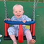 Adonis Joe joined the competition — help win amazing prizes! baby, child, swing, playground, smiling, happy, pajamas, barefoot, metal_chain, green_surface, outdoor, fence, fun, joy, infant, seat, toy, feet, person, daylight