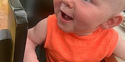 Adonis Joe joined the competition — help win amazing prizes! baby, child, high_chair, orange_clothing, smiling, happy, indoor, dining, table, seat, person, face, blue_eyes, shorts, crab_pattern, hand, skin, cute, young, infant