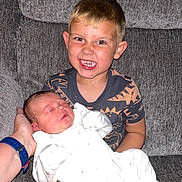 Willow is registered to the contest to win money with this photo: child, baby, newborn, boy, sleeping, smiling, couch, hand, clothing, indoor, family, love, happy, sibling, portrait, person, cute, infant, home, cozy