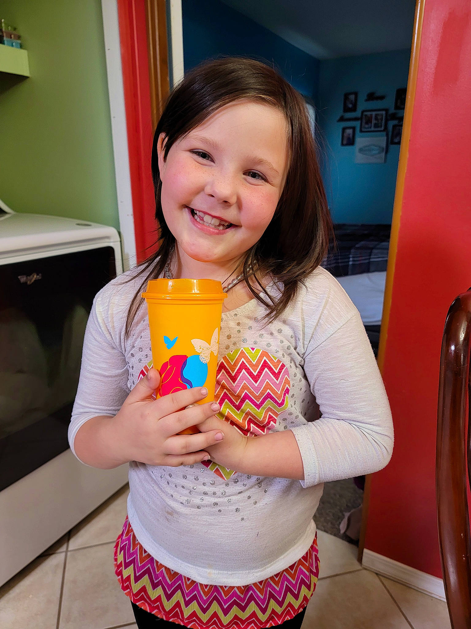 Desiree is registered to the contest to win money with this photo: chair, child, comfort_food, dairy, drink, event, facial_expression, food, fun, happy, home_appliance, joy, party, person, room, skin, smile, sweetness, t_shirt, tableware