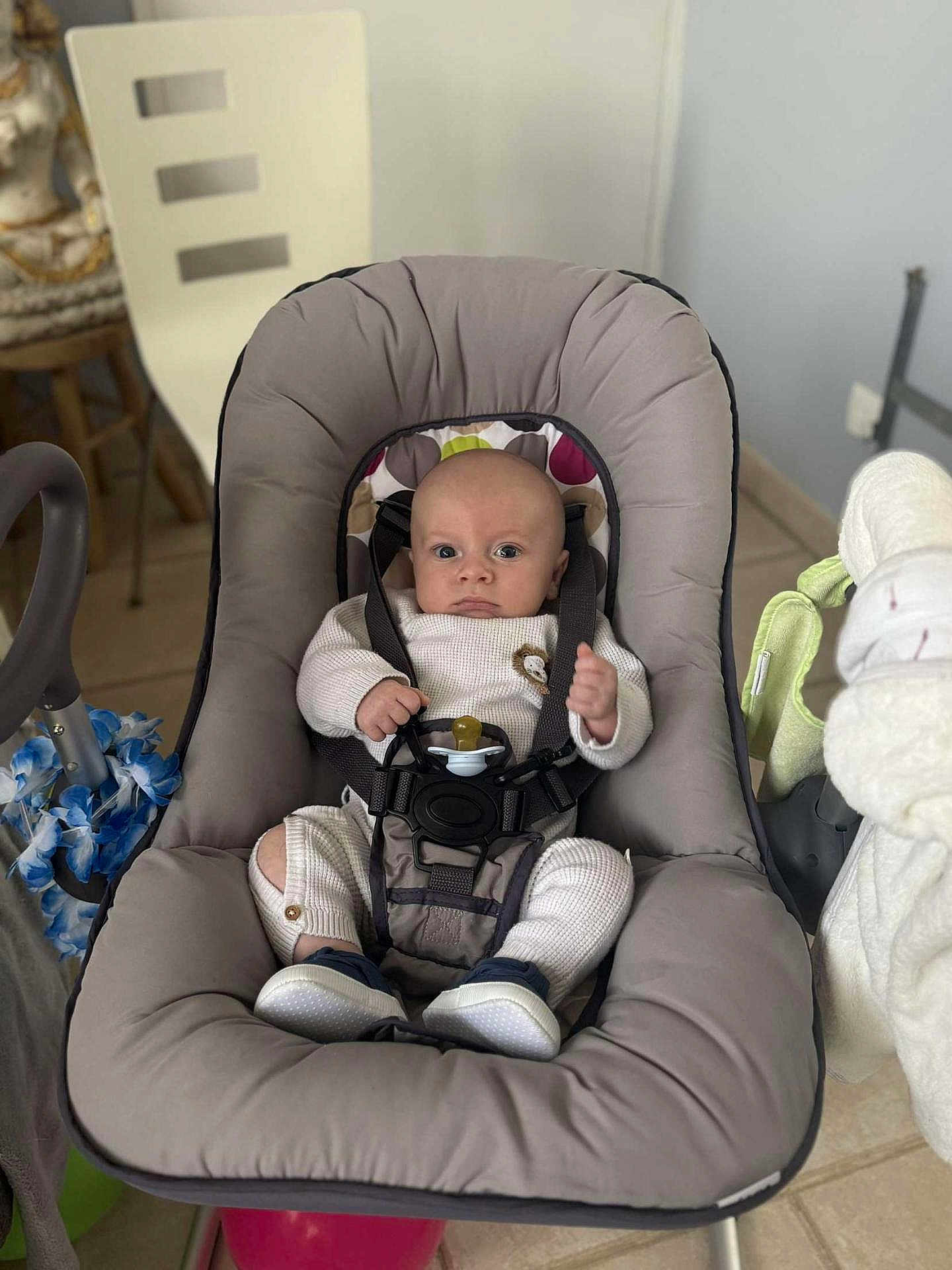 Thiago a rejoint le concours — aidez-le/la à gagner de superbes lots ! baby, infant, baby_seat, pacifier, knitted_outfit, lion_patch, straps, cushion, indoor, floor_tiles, chair, baby_shoes, baby_clothing, baby_toys, baby_care, person, face, baby_furniture, curious, safe