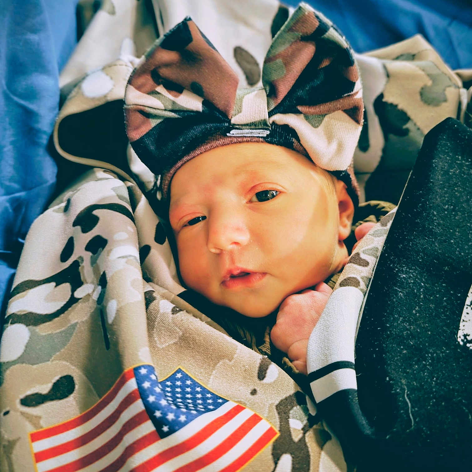 Aribella joined the competition — help win amazing prizes! american_flag, baby, blanket, blue_background, bow, camouflage, child, closeup, clothing, cute, fabric, flag, headband, infant, newborn, person, portrait, sleepy, soft, wrapped