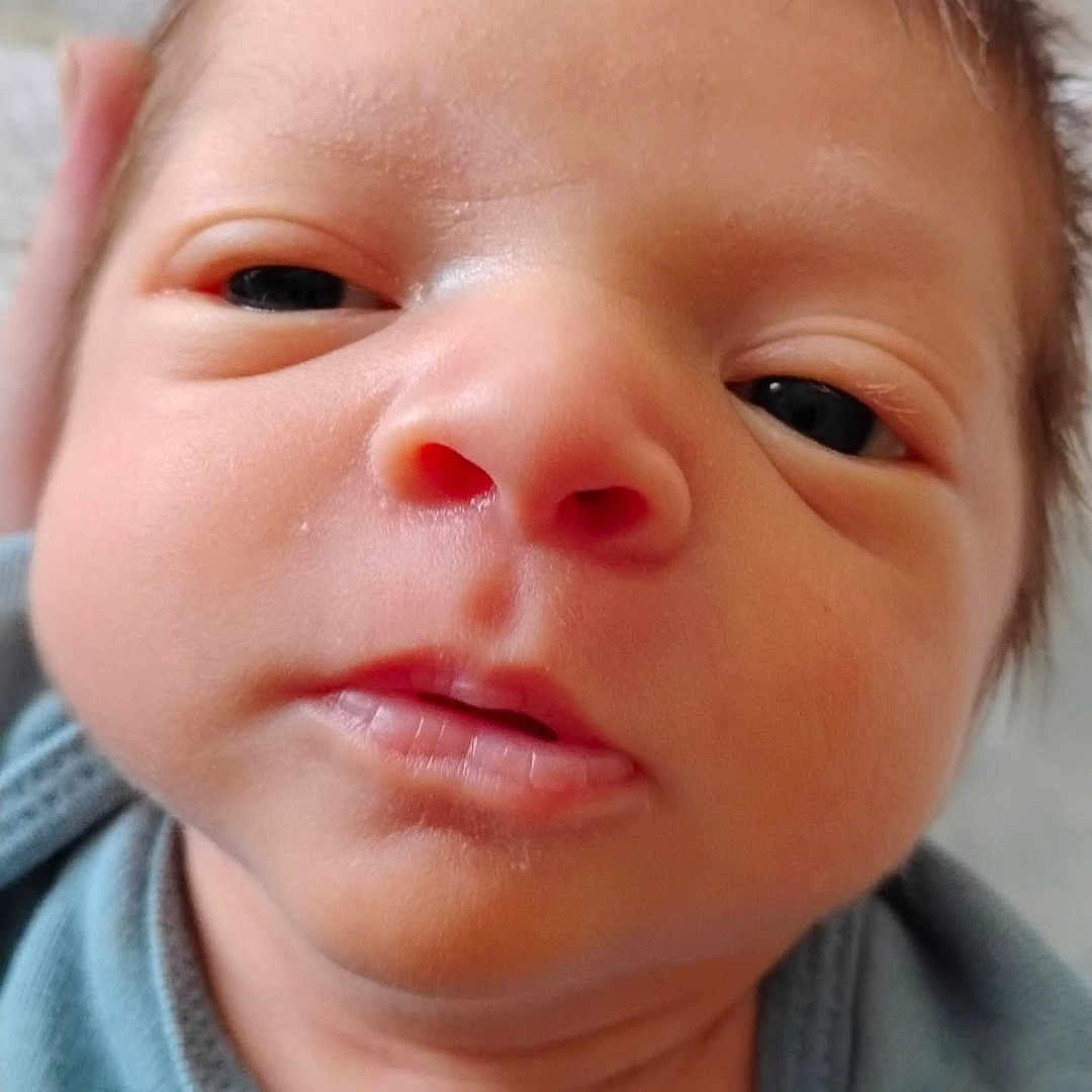 Jackson is registered to the contest to win money with this photo: baby, blue, child, closeup, clothing, cute, expression, eyes, face, hair, indoors, infant, mouth, newborn, person, portrait, skin, soft, tongue, young