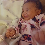 Storii is registered to the contest to win money with this photo: baby, blanket, child, comfort, cozy, cute, face, furniture, hand, happy, indoor, infant, pajamas, person, portrait, relaxed, sleepwear, smiling, soft, warm