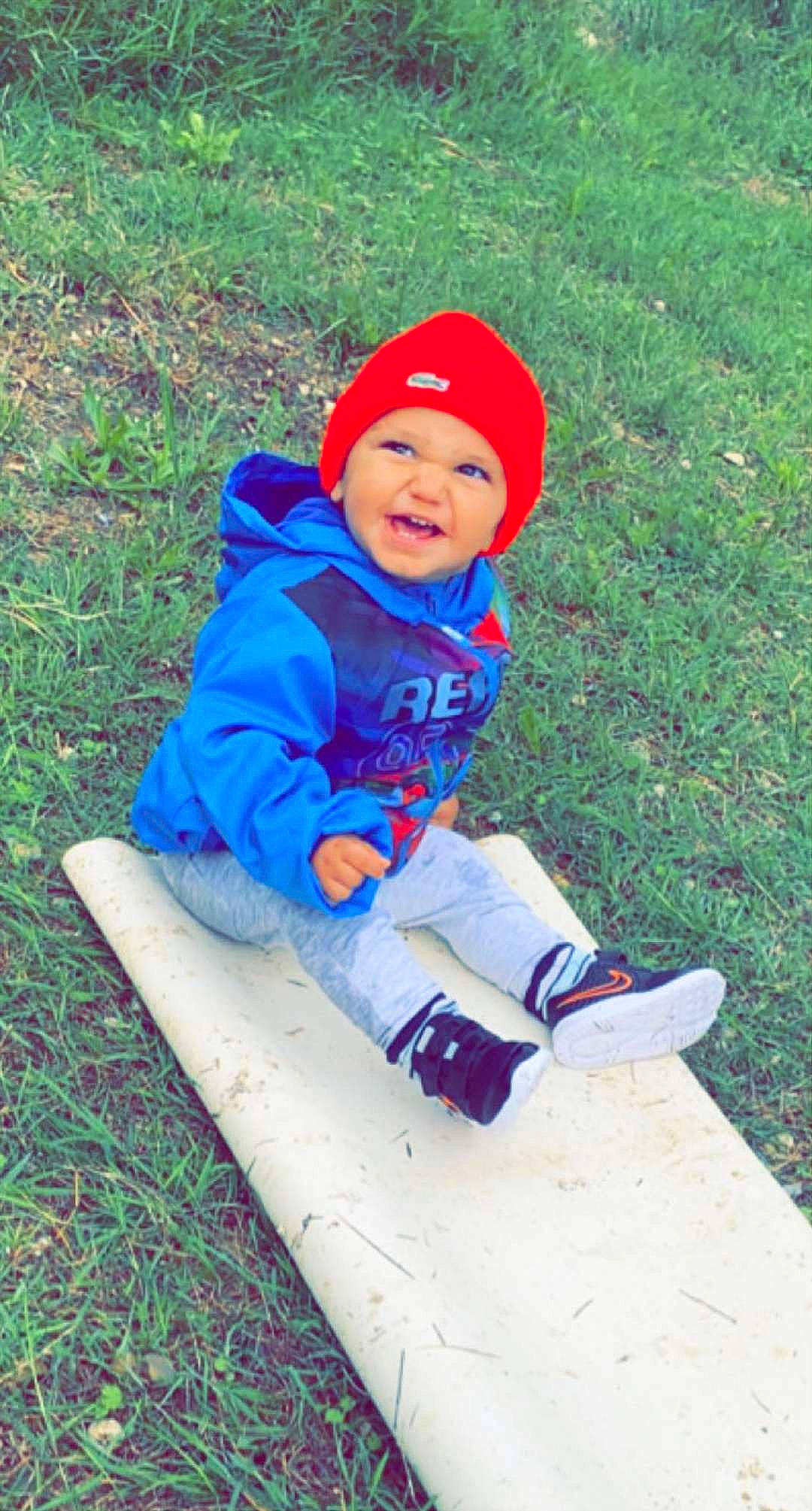 Maydën a rejoint le concours — aidez-le/la à gagner de superbes lots ! baby, baby_toddler_clothing, cap, child, electric_blue, face, fun, grass, hat, headwear, jacket, leisure, people_in_nature, person, plant, play, recreation, sitting, skateboarder, smile