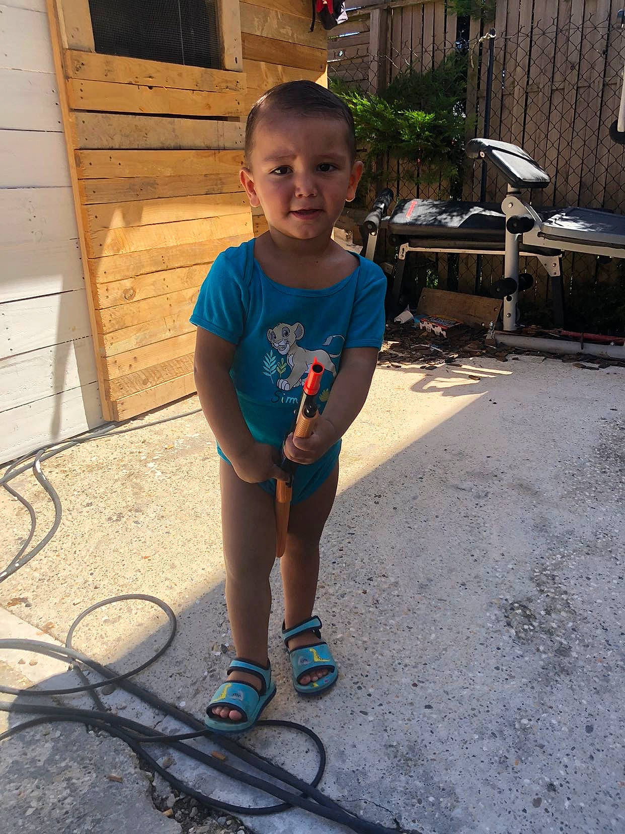 Maydën participe au concours pour gagner de l'argent avec cette photo : child, chin, daytime, electric_blue, flooring, fun, hairstyle, happy, head, human_leg, leg, leisure, person, sandal, shorts, sidewalk, standing, summer, t_shirt, toddler