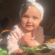 Azaryah a rejoint le concours — aidez-le/la à gagner de superbes lots ! baby, child, headwrap, smile, face, hand, blanket, pattern, leaf, sunlight, indoors, portrait, infant, cute, happy, clothing, lying_down, skin, warm_light, young