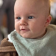 Maël a rejoint le concours — aidez-le/la à gagner de superbes lots ! baby, infant, face, eyes, bib, head, cheeks, ear, mouth, portrait, closeup, clothing, sweater, hand, finger, soft_light, shallow_depth_of_field, bokeh, cute, indoor