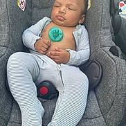 Kamarion is registered to the contest to win money with this photo: baby, infant, sleeping, car_seat, pacifier, striped_clothing, onesie, child, outdoor, gray, seat_belt, curly_hair, peaceful, resting, cute, small_hands, closed_eyes, fabric, comfort, relaxation
