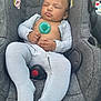 baby, infant, sleeping, car_seat, pacifier, striped_clothing, onesie, child, outdoor, gray, seat_belt, curly_hair, peaceful, resting, cute, small_hands, closed_eyes, fabric, comfort, relaxation