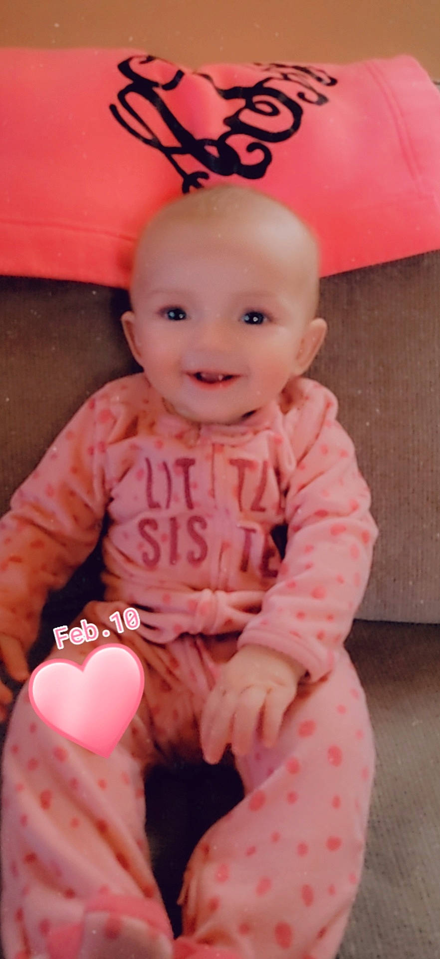 Emberlynn is registered to the contest to win money with this photo: baby, baby_toddler_clothing, cheek, child, design, facial_expression, flooring, font, happy, joy, magenta, peach, person, pink, red, sitting, skin, sleeve, smile, standing