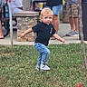 child, toddler, blond_hair, blue_eyes, outdoor, grass, walking, running, playful, portrait, full_body, black_shirt, blue_jeans, sneakers, crowd, park, sidewalk, stone_pillar, photograph, phone_watermark