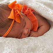 Iszelie is registered to the contest to win money with this photo: newborn, baby, sleeping, headband, orange_bow, orange_clothing, blanket, white_lace, infant, peaceful, cute, portrait, closeup, soft_texture, resting, child, adorable, sleep, cozy, toddler