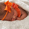 newborn, baby, sleeping, headband, orange_bow, orange_clothing, blanket, white_lace, infant, peaceful, cute, portrait, closeup, soft_texture, resting, child, adorable, sleep, cozy, toddler