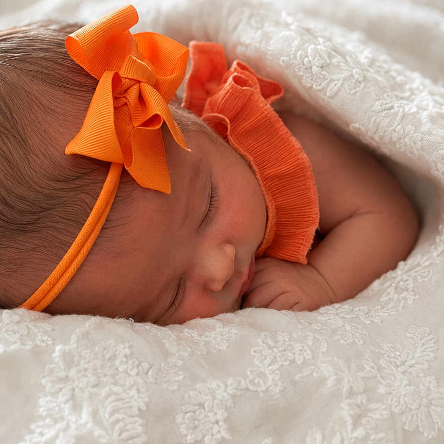 Iszelie is registered to the contest to win money with this photo: newborn, baby, sleeping, headband, orange_bow, orange_clothing, blanket, white_lace, infant, peaceful, cute, portrait, closeup, soft_texture, resting, child, adorable, sleep, cozy, toddler