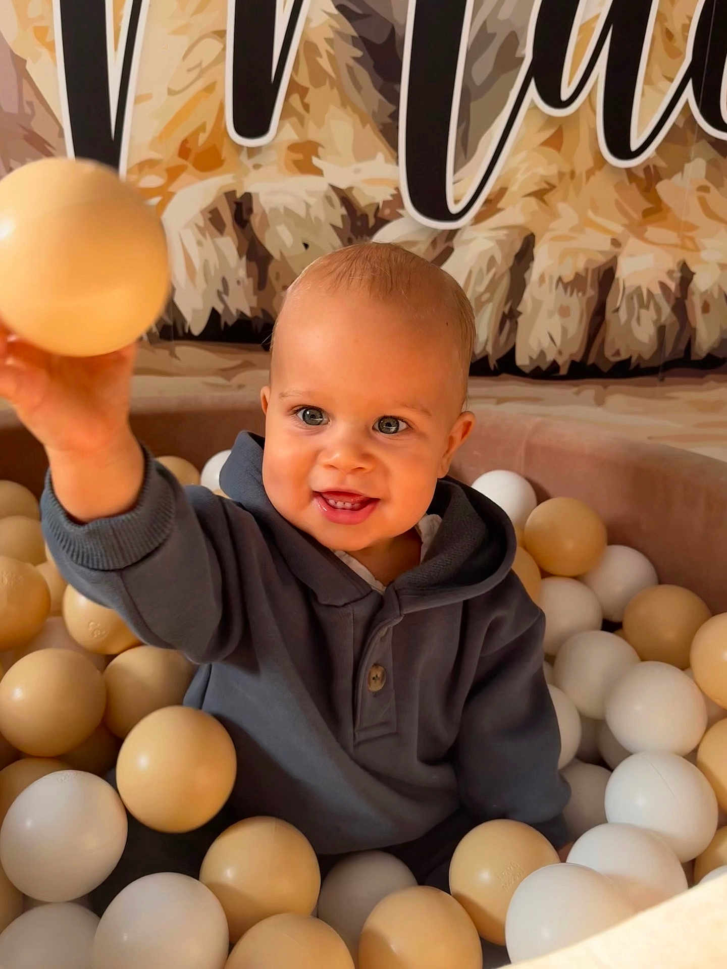 Maë participe au concours pour gagner de l'argent avec cette photo : toddler, child, ball_pit, beige_balls, white_balls, smiling, happy, hoodie, indoor, play, cute, baby, portrait, face, childhood, fun, hand, toy, expression, person