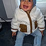 toddler, child, smiling, blue_hat, fleece_jacket, jeans, sneakers, indoor, window, floor, happy, cute, baby, clothing, person, portrait, seated, casual, headwear, footwear
